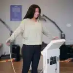 woman in cream shirt standing on scale for body scan